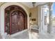 Ornate wooden front door featuring elaborate carvings, complemented by decorative lighting and accents at 1577 Alexander Rd, Belleair, FL 33756