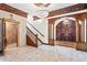 Elegant foyer with decorative chandeliers, staircase, and ornate woodwork throughout at 1577 Alexander Rd, Belleair, FL 33756