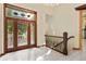 Elegant foyer featuring a decorative glass front door, tiled floors, and ornate stairwell at 1577 Alexander Rd, Belleair, FL 33756