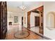 Grand foyer with detailed flooring, pillars, arched doorway, a decorative chandelier, and alcoves at 1577 Alexander Rd, Belleair, FL 33756