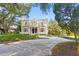 Stunning brick home boasting a circular driveway, manicured landscaping, and a grand entrance at 1577 Alexander Rd, Belleair, FL 33756