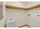 Bright laundry room featuring tile flooring, a utility sink, shelves and a hook bar for hanging your clothing at 1577 Alexander Rd, Belleair, FL 33756