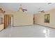 Living room featuring tile floors, ceiling fans, two windows, and access to a possible Primary bathroom at 1577 Alexander Rd, Belleair, FL 33756