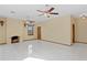 Living room with tile floors, a fireplace, and one standard door, one window, ceiling fans with lights at 1577 Alexander Rd, Belleair, FL 33756