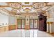 An ornate living room with decorative ceiling, fireplace, and access to the porch at 1577 Alexander Rd, Belleair, FL 33756
