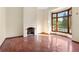 Sunlit living room with a fireplace and a bay window overlooking the landscaped yard at 1577 Alexander Rd, Belleair, FL 33756