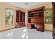 Spacious office with beautiful built-in shelves, desk, neutral paint, ceiling fan and a large window for tons of natural lighting at 1577 Alexander Rd, Belleair, FL 33756