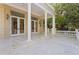 Covered porch with white columns, stone tile floor, and large windows at 1577 Alexander Rd, Belleair, FL 33756