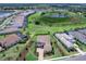 Panoramic view showcasing a home with a tile roof, paved driveway, and extensive landscaping near a large pond at 17114 Verona Pl, Lakewood Ranch, FL 34202