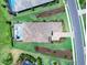 Overhead perspective of a home showcasing its tile roof, pool, paved driveway, and meticulously maintained landscaping at 17114 Verona Pl, Lakewood Ranch, FL 34202