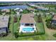 Aerial view of a large home's backyard with a pool, spa, manicured lawn, and landscaping in a lakeside community at 17114 Verona Pl, Lakewood Ranch, FL 34202