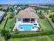 Aerial view of a home's backyard featuring a pool, spa, outdoor seating, and well-manicured landscaping at 17114 Verona Pl, Lakewood Ranch, FL 34202