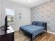 Cozy bedroom with stylish accent wall, wood-look floors and comfortable bed at 17114 Verona Pl, Lakewood Ranch, FL 34202