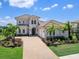 Elegant home featuring a tile roof, well-manicured landscaping, and a brick driveway, exuding curb appeal at 17114 Verona Pl, Lakewood Ranch, FL 34202