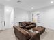 Spacious living room furnished with leather seating and ottoman near bright windows at 17114 Verona Pl, Lakewood Ranch, FL 34202