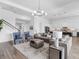 Bright, open-concept living room features modern lighting, neutral tones, and seamless flow to the kitchen at 17114 Verona Pl, Lakewood Ranch, FL 34202