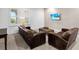 Living area furnished with two club chairs, a sofa, an ottoman, and a wall mounted television at 17114 Verona Pl, Lakewood Ranch, FL 34202