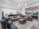 Spacious living room featuring comfortable seating, a large rug, and open access to the kitchen and dining area at 17114 Verona Pl, Lakewood Ranch, FL 34202