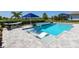 Backyard pool boasts luxury chaise lounges, water feature, and hammock with sunny views at 17114 Verona Pl, Lakewood Ranch, FL 34202