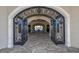 Elegant clubhouse entrance with iron gates, stone archway, and tiled flooring, inviting visitors inside at 17118 Vardon Ter # 307, Bradenton, FL 34211