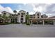 Attractive multi-story condo building with lush landscaping, covered parking, and visible accessibility parking at 17118 Vardon Ter # 307, Bradenton, FL 34211