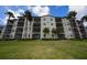 The rear of the condo building features screened patios and lush lawns enhanced by palm trees at 17118 Vardon Ter # 307, Bradenton, FL 34211