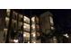 Exterior view of a condo building at night, illuminated with lights and palm trees at 17118 Vardon Ter # 307, Bradenton, FL 34211
