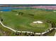 Expansive golf course with lush green fairways and a meandering water hazard under a bright sky at 17118 Vardon Ter # 307, Bradenton, FL 34211