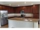 Beautiful kitchen featuring stainless steel appliances, an island, granite countertops and dark wood cabinets at 17118 Vardon Ter # 307, Bradenton, FL 34211