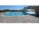 Large community pool featuring a zero entry side and rock waterfall, surrounded by luxurious hardscape and landscaping at 17118 Vardon Ter # 307, Bradenton, FL 34211