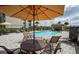 Relaxing community pool area with ample lounge chairs, umbrella-covered tables, and beautiful surroundings at 17118 Vardon Ter # 307, Bradenton, FL 34211