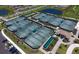 Aerial view of multiple tennis courts and lush landscaping at 17118 Vardon Ter # 307, Bradenton, FL 34211