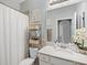 Well-lit bathroom featuring a clean, white vanity, shower with curtain and practical storage solutions at 17902 Gawthrop Dr # 401, Bradenton, FL 34211