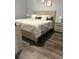 Bedroom with dark wood floors, neutral bedding, and natural light for a comfortable space at 17902 Gawthrop Dr # 401, Bradenton, FL 34211