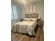 Comfortable bedroom featuring a queen bed, stylish headboard, and warm wood-look flooring at 17902 Gawthrop Dr # 401, Bradenton, FL 34211