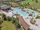 Aerial view of the community's resort-style pool with waterfall feature, surrounded by palm trees and lounge chairs at 17902 Gawthrop Dr # 401, Bradenton, FL 34211