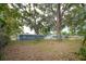 Fenced backyard featuring mature trees, storage shed, and grass at 1823 8Th E Ave, Bradenton, FL 34208