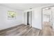 Bedroom with wood-look floors, closet with folding doors, and view into a connecting room at 2005 47Th Street W Ct, Bradenton, FL 34209