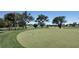 Golf course view with manicured green, mature trees, and a water feature in the background at 2005 47Th Street W Ct, Bradenton, FL 34209