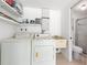 Cozy laundry room features a washer, dryer, shelving, and access to a bathroom at 2005 47Th Street W Ct, Bradenton, FL 34209
