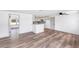 Open-concept living room with light wood flooring and a view into the modern kitchen, offering ample space at 2005 47Th Street W Ct, Bradenton, FL 34209