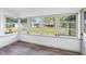 Sunroom featuring wood-look flooring and multiple windows providing ample natural light and view to fenced backyard at 2005 47Th Street W Ct, Bradenton, FL 34209