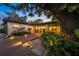 Beautiful backyard features a wooden deck, lush landscaping, and outdoor lighting that creates a serene retreat at 2124 Wisteria St, Sarasota, FL 34239
