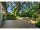 Inviting backyard area featuring a spacious wooden deck, lush green landscaping, and beautiful trees at 2124 Wisteria St, Sarasota, FL 34239