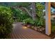 This wooden walkway features landscape lighting and lush landscaping, that creates a whimsical and inviting outdoor space at 2124 Wisteria St, Sarasota, FL 34239