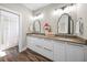 Bright bathroom featuring double sinks with modern vanities and large mirrors over wood look tile floors at 2124 Wisteria St, Sarasota, FL 34239