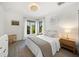 Bright bedroom with neutral tones, large windows, wood nightstand, and accent pillows for a serene, relaxing atmosphere at 2124 Wisteria St, Sarasota, FL 34239