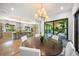 Open dining area with modern chandelier, and sliding doors with views to outdoor spaces and kitchen area at 2124 Wisteria St, Sarasota, FL 34239