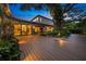 A cozy outdoor deck and lush backyard, adjacent to a large, modern home, perfect for outdoor relaxation at 2124 Wisteria St, Sarasota, FL 34239