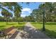 Park features a walkway, bench, fountain, and pond surrounded by lush greenery under a blue sky, great for relaxation at 2124 Wisteria St, Sarasota, FL 34239
